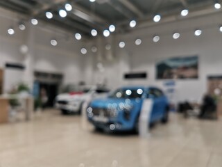 Blurred new car parked in modern showroom waiting for sales.