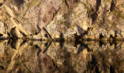 Abstract carvings of ocean waves in shore rocks
