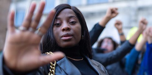 Confident black woman protesting against racial discrimination isolated on urban background - Young diverse african woman showing black lives matter gesture - stop racism, human rights concept - obrazy, fototapety, plakaty