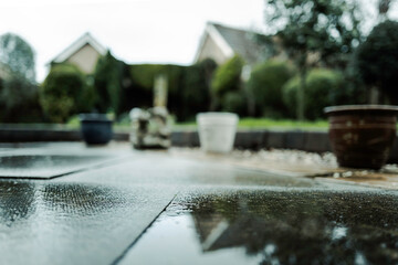 Ground level, shallow focus of a wet patio blocks seen in a back yard are a heavy downpour in...