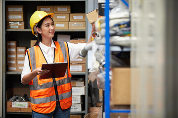factory worker holding a clipboard and looking at shelf in warehouse storage