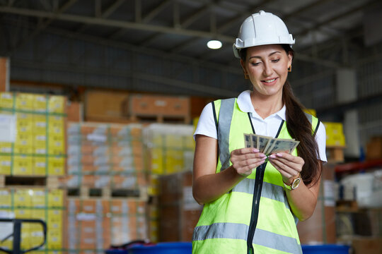 factory worker counting money in the warehouse storage
