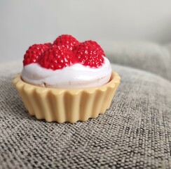 Berries cupcake toy with cream on gray background