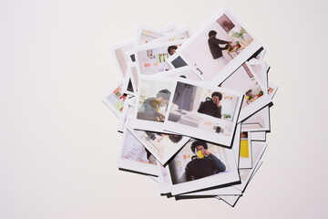 heap of Polaroid photos depicting various candid moments of an entrepreneur's life at work, from deep in thought to enjoying a simple coffee break, against the backdrop of a vibrant and energetic work