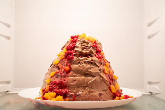 Homemade chocolate and fruit cake in a shape of a volcano inside a fridge, shallow depth of field