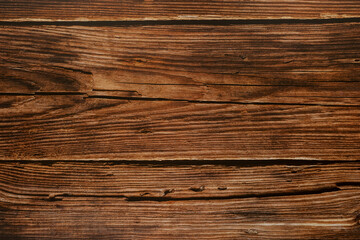 Texture of dark brown horizontal wooden boards with transverse cracks