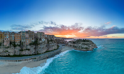 view of Rotonda Beach and the colourful old town of Tropea in Calabria at sunset