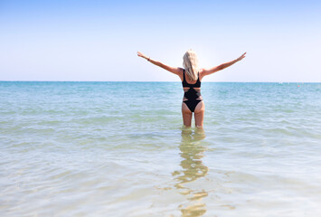 Fototapeta na wymiar Woman in black swimwear on the beach