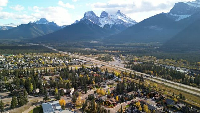 Canmore, Alberta, Canada. Aerial view of Trans-Canada Highway (Highway 1) in a autumn sunny day. The Three Sisters trio of peaks Canadian Rockies mountain range.
