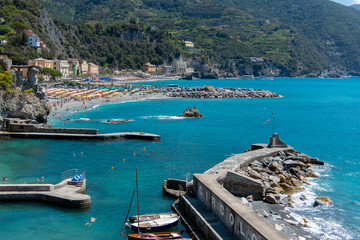 Fototapeta premium Monterosso, Italy, July 27, 2023. Beach and parasols in front of the giant, statue of the giant god Poseidon or Neptune