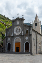 Fototapeta na wymiar Riomaggiore, Italy, July 29, 2023. The church of San Giovanni Battista. This basilica, dedicated to the patron saint of the village, is located in the upper part of the historic center