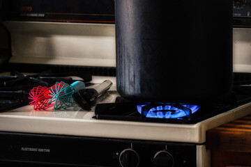 A typical Kitchen scene in almost every American household.  Black pot on a gas burner.  Colorful...