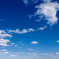 Naklejka na ściany i meble A bright blue sky with white clouds on a sunny day.