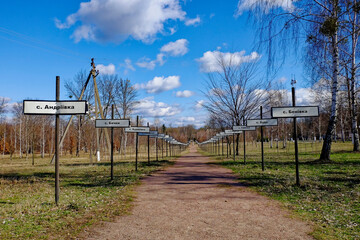 A rural landscape shot with a wide view of the path and signs. Alley with the names of abandoned...