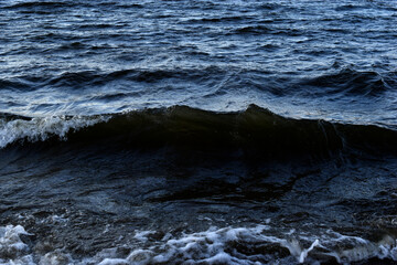 Black waves of the reservoir in winter in the mountains. The dark waters of the reservoir in Yekaterinburg.