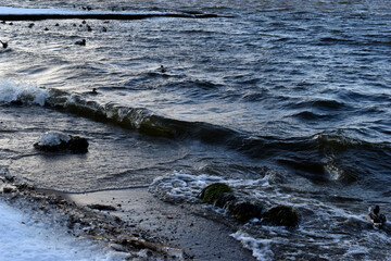 Black waves of the reservoir in winter in the mountains. The dark waters of the reservoir in Yekaterinburg.