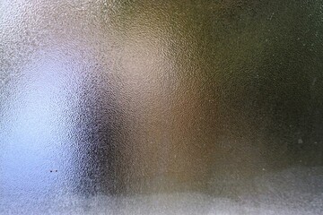 Beschlagene Fensterscheibe mit Muster und Rand mit Frost als Hintergrund
