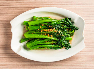 stirred fried seasonal vegetable chinese broccoli or kai lan with chopped garlic served in dish...