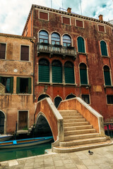 Narrow canal and small bridge in the city of Venice.