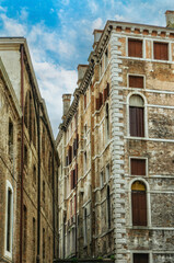 Fototapeta premium Facades of weathered buildings with windows on street of Venice city