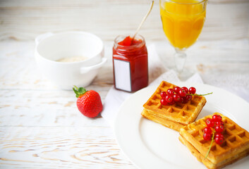 Waffles with red currant jam, orange juice and oat flakes oatmeal