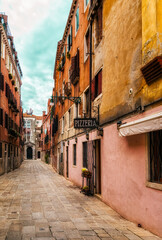 Quaint street in historic Venice, Italy with Pizzeria sign