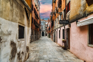 Fototapeta na wymiar Quaint street in historic Venice, Italy with Pizzeria sign