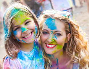 Obraz premium Happy mother with little daughter on holi festival