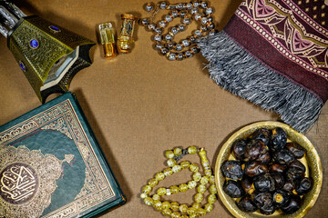 muslim book with arabic calligraphy Quran translation : holy book of Muslims and oud perfume and censer, dates fruit, tasbih and prayer mat. iftar ramadan concept