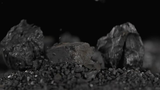 Super Slow Motion Shot of Spilling Crushed Coal Isolated On Black Background at 1000 fps.