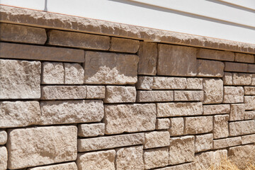 Natural stone veneer instal on the foundation of a home. Stone mason work. - obrazy, fototapety, plakaty