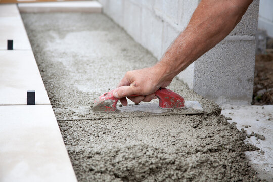 Mason working a with trowel. Stone mason.