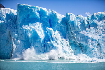 Huge avalanche from a glacier in the water causing a huge wave and splash illustrating climate change