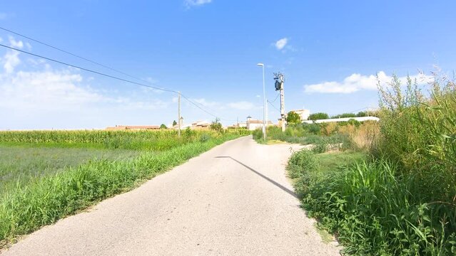 a paved road through agricultural fields entering Boldu village, municipality of La Fuliola, comarca of Urgel, Province of Lleida, Catalonia, Spain