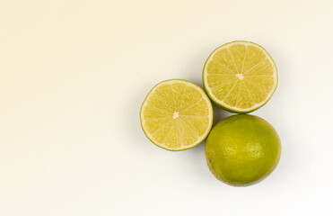 Halves or slices of green lime on light white background. Fresh fruits with copy space for text
