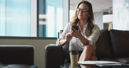 Cellphone, networking and business woman on sofa browsing on social media, mobile app or internet. Technology, office lounge and professional female creative designer scroll on a phone in workplace.