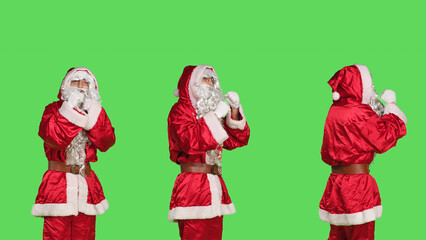 Violent saint nick throw punches in the air, acting aggressive with clenched fists. Strong santa claus character in costume ready for fight, confident person cosplay on greenscreen.