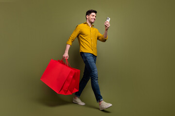 Full length photo of attractive brunet man wear stylish clothes carry packages step store mall...