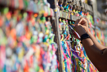 People are seen paying homage to Senhor do Bonfim by tying a souvenir ribbon on the church's iron...