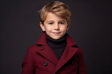 Portrait of a cute little boy in a red coat. Studio shot.