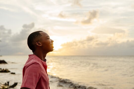 Young Adult Black Man Breathing Fresh Air On The Beach	
