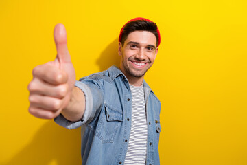 Photo of positive confident man dressed jeans shirt showing you thumb up isolated yellow color background