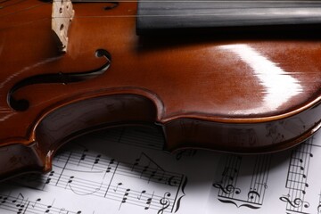 Classic violin on music sheets, closeup view