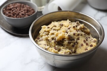 Chocolate chip cookie dough in bowl on table, closeup