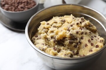 Chocolate chip cookie dough in bowl on table, closeup