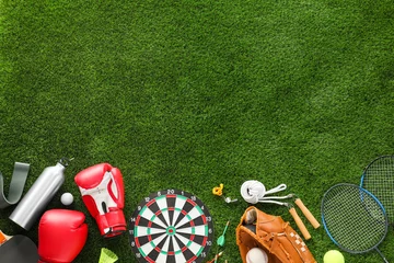 Zelfklevend Fotobehang Different sport equipment on green grass, flat lay. Space for text © New Africa