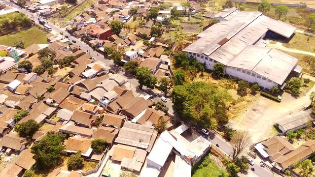 Drone footage. Aerial video of Residential Area in Suburban Village in West Java - Indonesia. The slopes and valleys are filled with residential areas and rice fields. Aerial Shot from a flying drone 