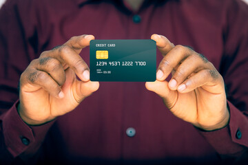 close up of business man in red wine long sleeves shirt holding generic black credit card showing...