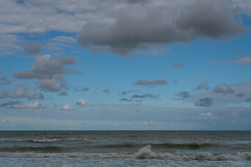 View of the stormy Baltic Sea against a cloudy sky on a sunny summer day, Curonian Spit, Kaliningrad region, Russia