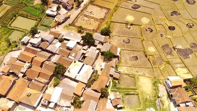 Drone footage. Aerial video of Residential Area in Suburban Village in West Java - Indonesia. The slopes and valleys are filled with residential areas and rice fields. Aerial Shot from a flying drone 